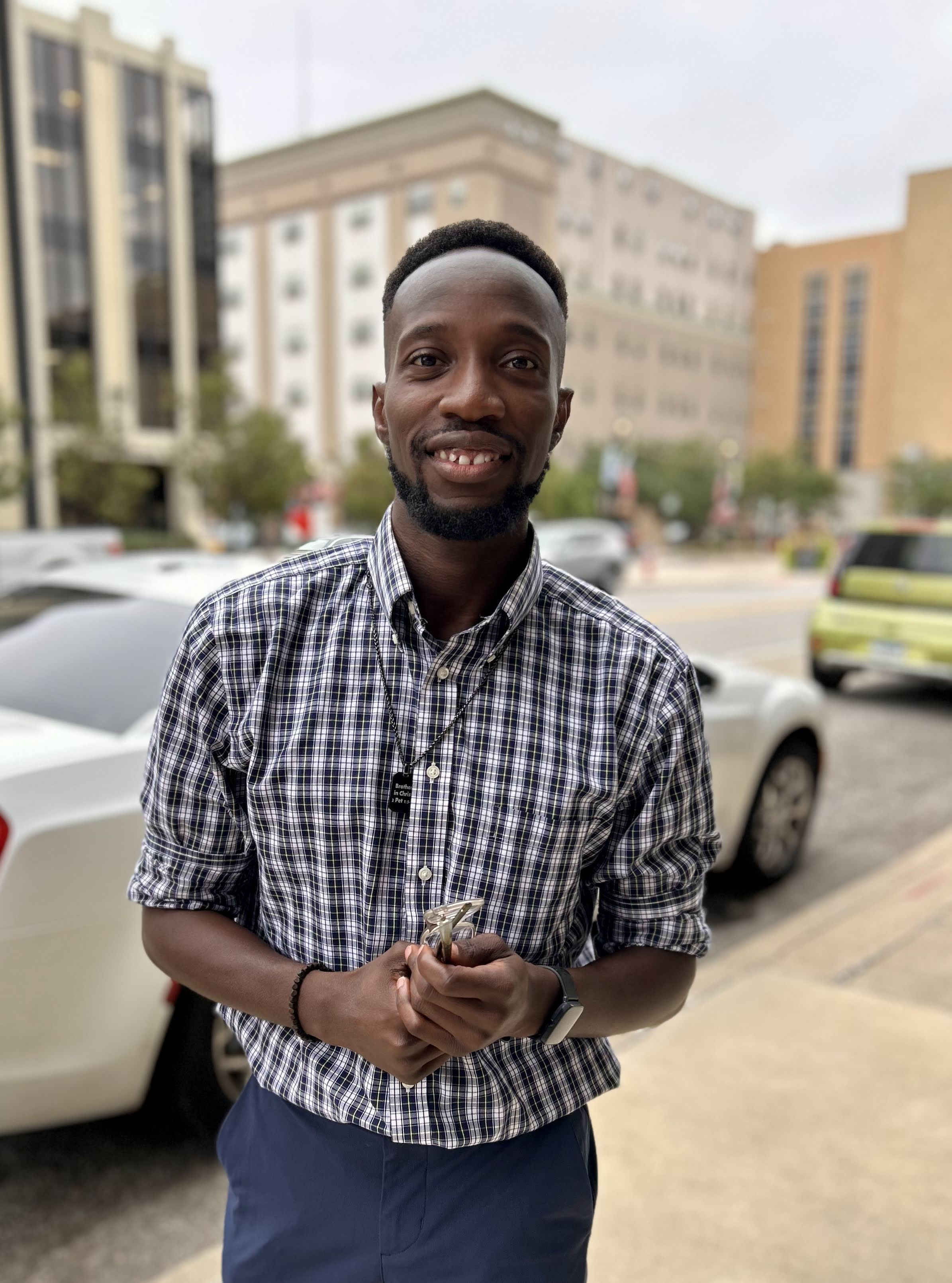 Yinka Oyebanjo-Odofin smiling in a patterned shirt outdoors